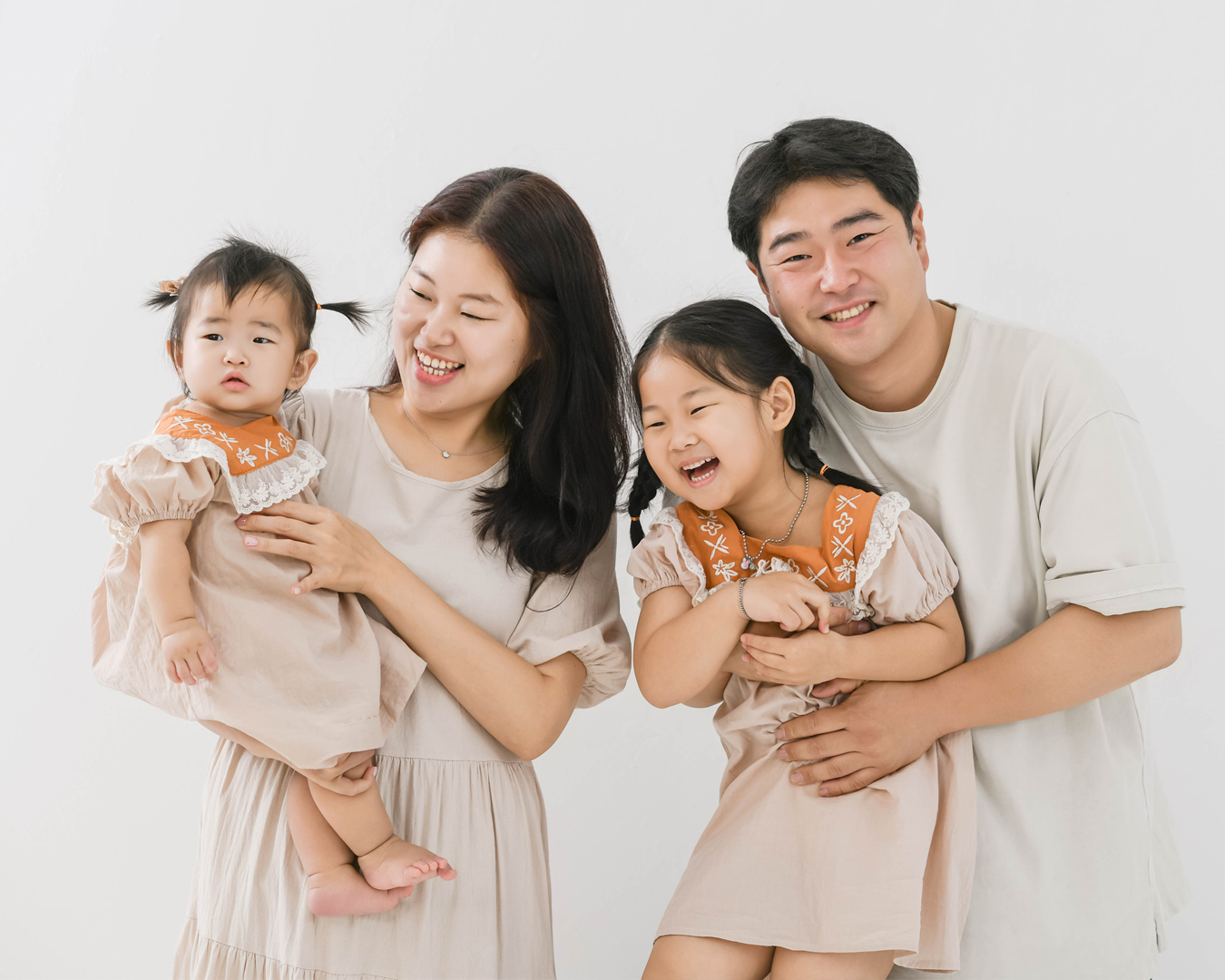 밝은 배경에서 두 아이와 함께 웃는 가족